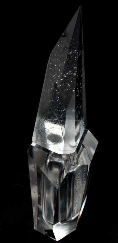 Aura — angled view of a faceted perfume bottle with engraved text
