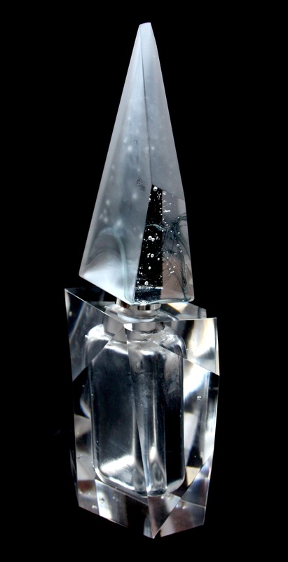 Aura — perfume bottle with tall frosted pointed stopper on black