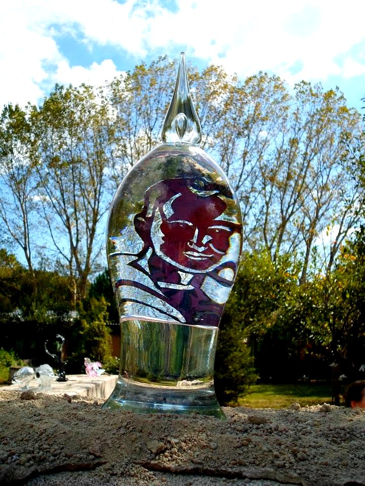 Close view of the copper portrait seen through the water inside the glass